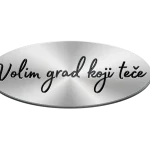 Ovalna magnetna naljepnica za auto s elegantnim efektom brušenog metala (srebrna pozadina). Na sredini crnim, pisanim slovima piše poznati slogan grada Rijeke: "Volim grad koji teče".